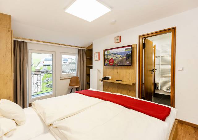 Hotelzimmer mit großem Bett und Zugang zur Terrasse.