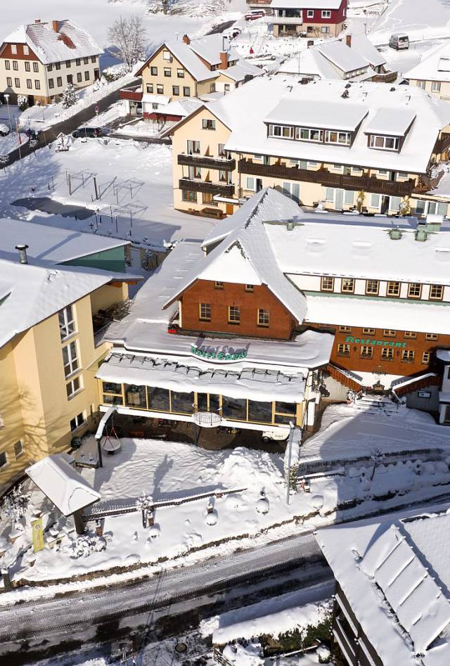 Detailaufnahme eines Hotels inmitten einer tief verschneiten Winterlandschaft.