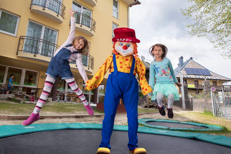 Kinder hüpfen mit Happy auf Trampolin