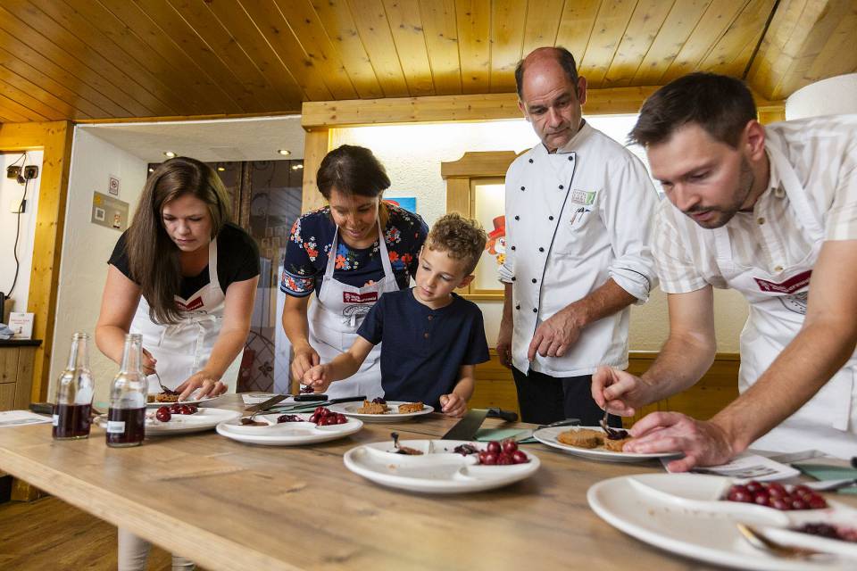 Gemeinsames Backen: Erwachsene und Kinder bereiten eine Torte zu.