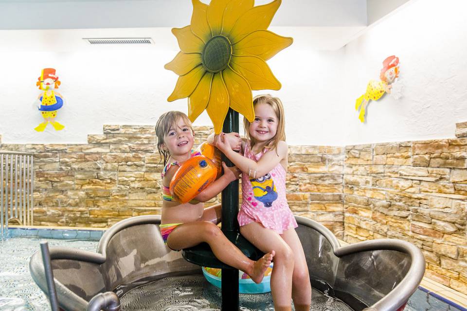 Zwei Mädchen sitzen auf Blume im Wasser