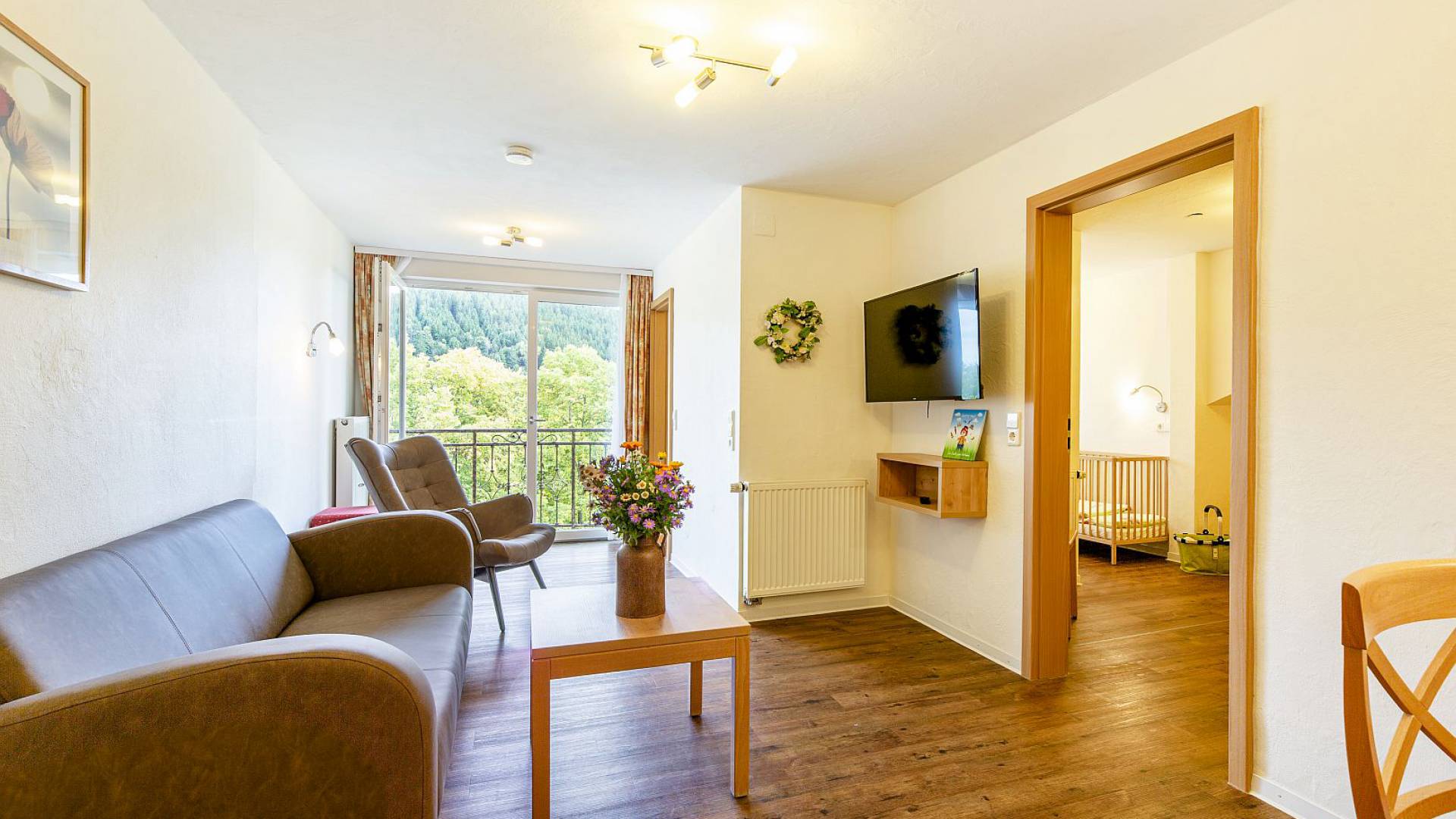Helles Wohnzimmer mit Balkonzugang und gemütlicher Einrichtung.