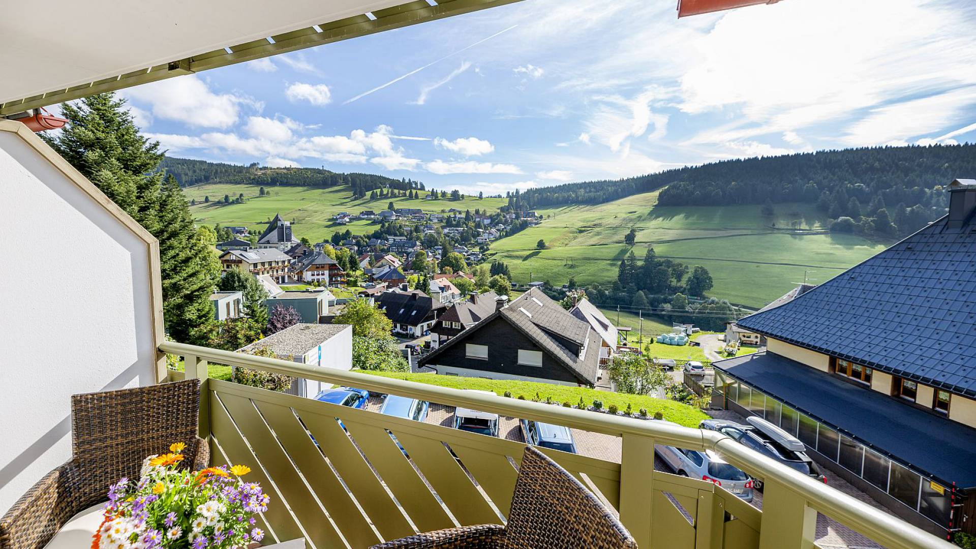 Balkon mit Panoramablick auf grüne Wiesen und Berge.