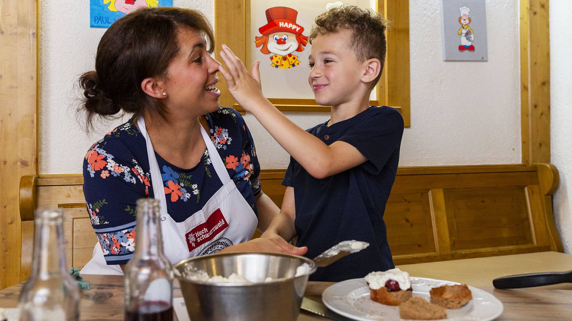 Mutter und Kind genießen gemeinsam ein Stück frisch gebackene Torte.