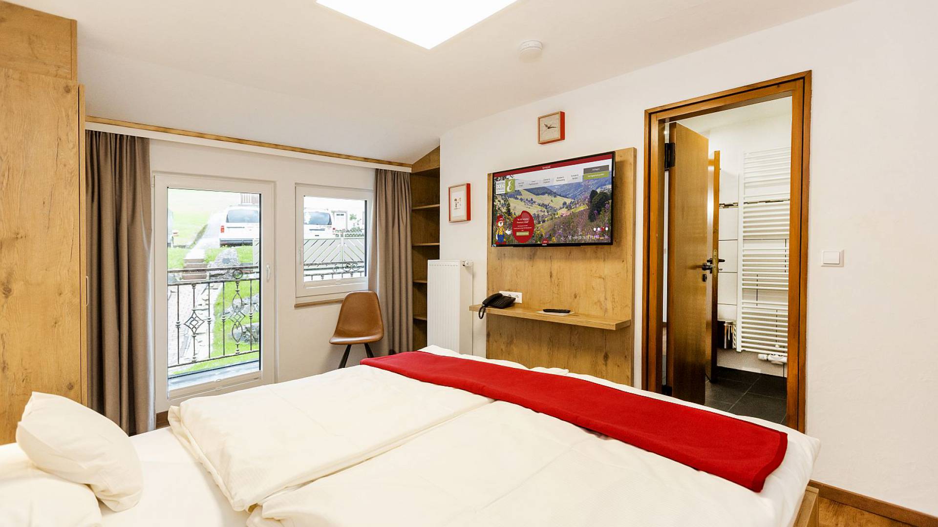 Hotelzimmer mit großem Bett und Zugang zur Terrasse.