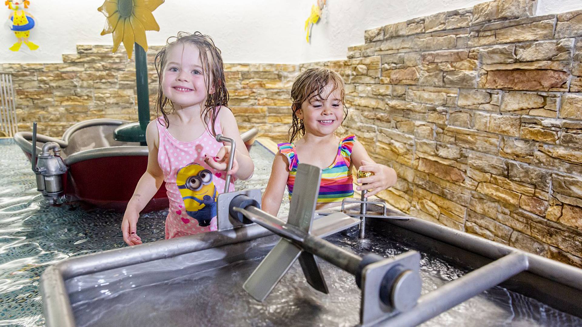 Mädchen spielen mit Wasserrad