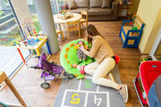 Mutter mit Säugling auf Spielteppich