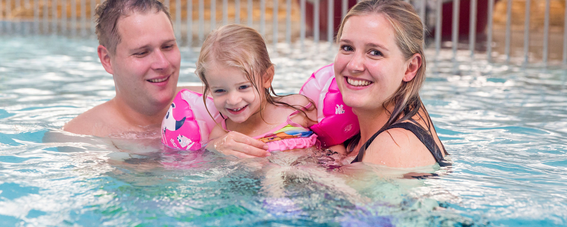 Familie mit Kind im Schwimmbad